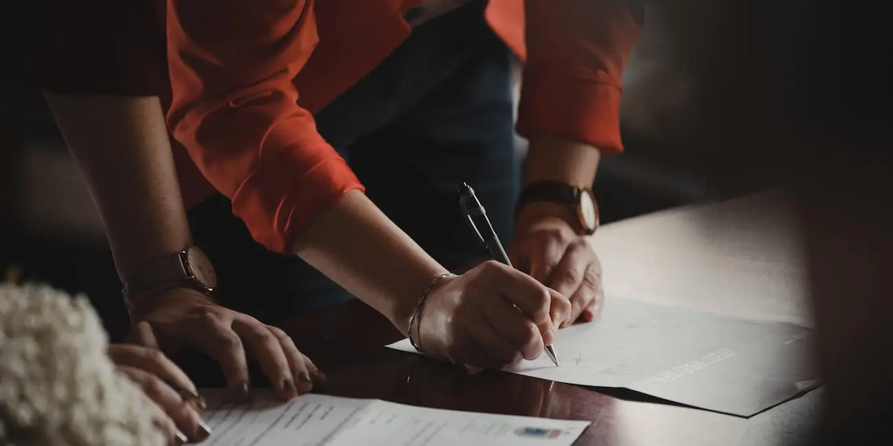 pareja firmando un acuerdo de liquidación de bienes de la sociedad conyugal