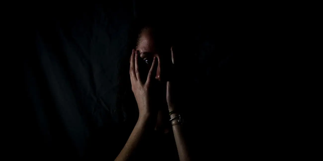Mujer tapándose la cara por ser objeto de violencia